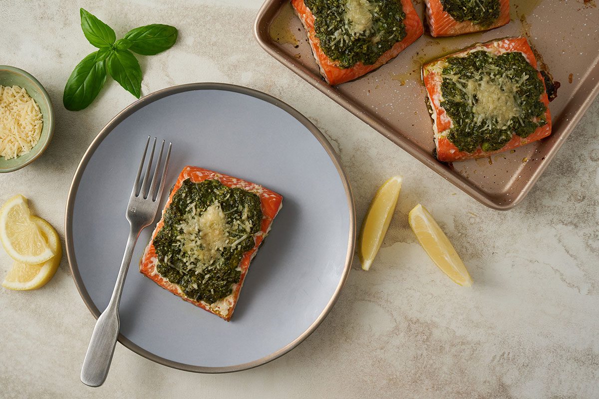 Overhead hero shot of the Taste of Home Basil Salmon, showcasing the rich pesto and melted Parmesan topping on perfectly baked salmon fillets.