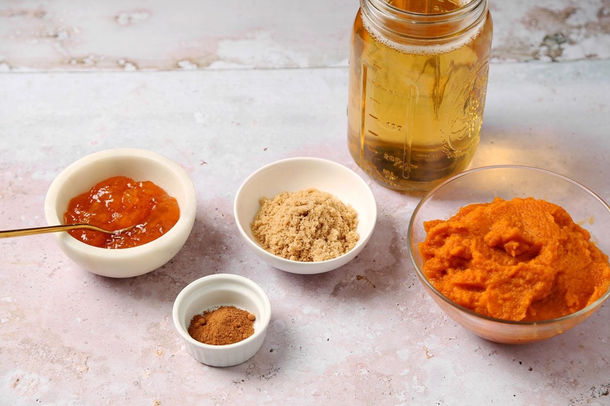 Ingredients for Taste of Home's Pumpkin Juice laid out in small bowls on a grey marble surface.