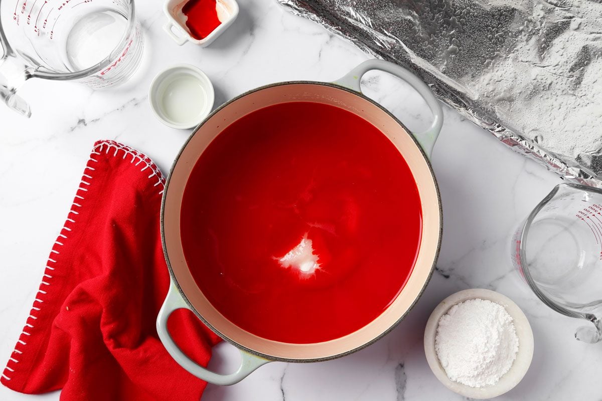 Process of making Taste of Home's cinnamon hard candy in a baking sheet on a grey marble surface.