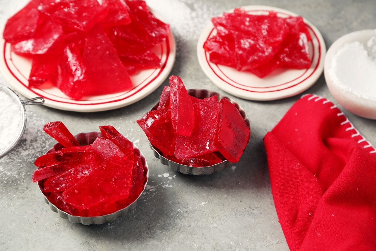 Close up of Taste of Home's cinnamon hard candy in small serving dishes on a grey marble surface.