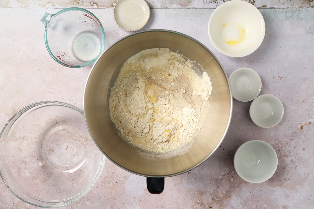 Process of making Taste of Home's Italian Sweet Bread dough being made in a mixer bowl on a grey and beige surface.