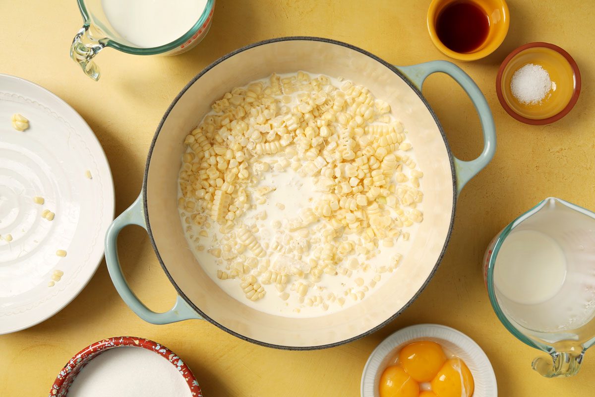 Process of making Taste of Home's Corn Ice Cream in a large pot on a yellow surface.