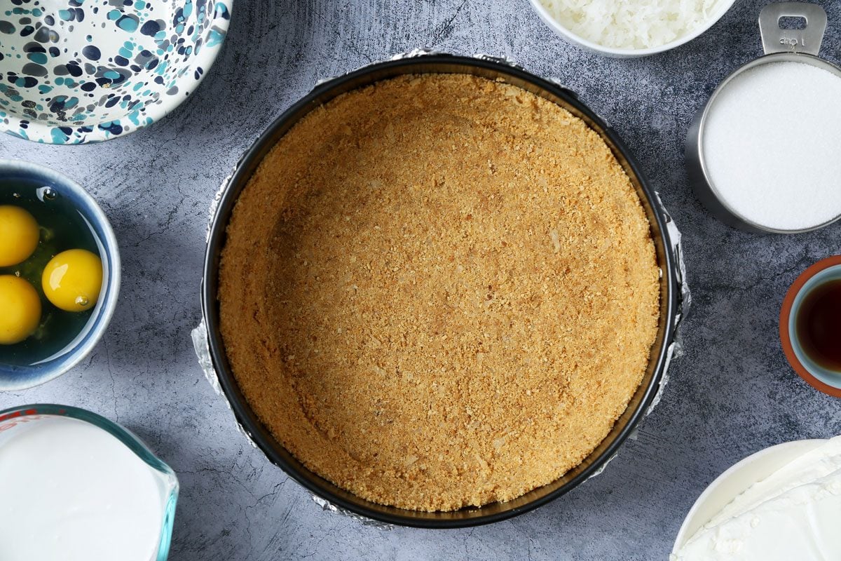 Process of making Taste of Home's Coconut Cheesecake on a dark blue surface.