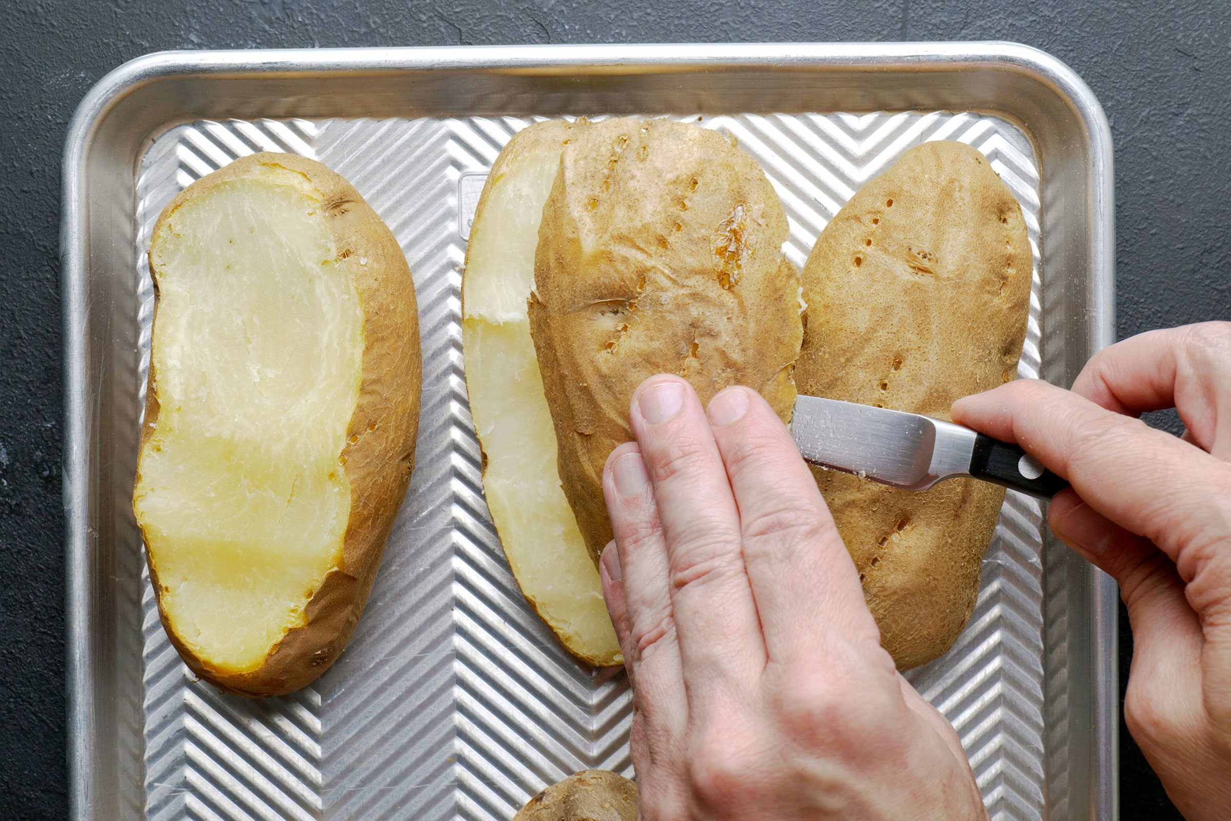 Cutting a thin slice off of a baked potato