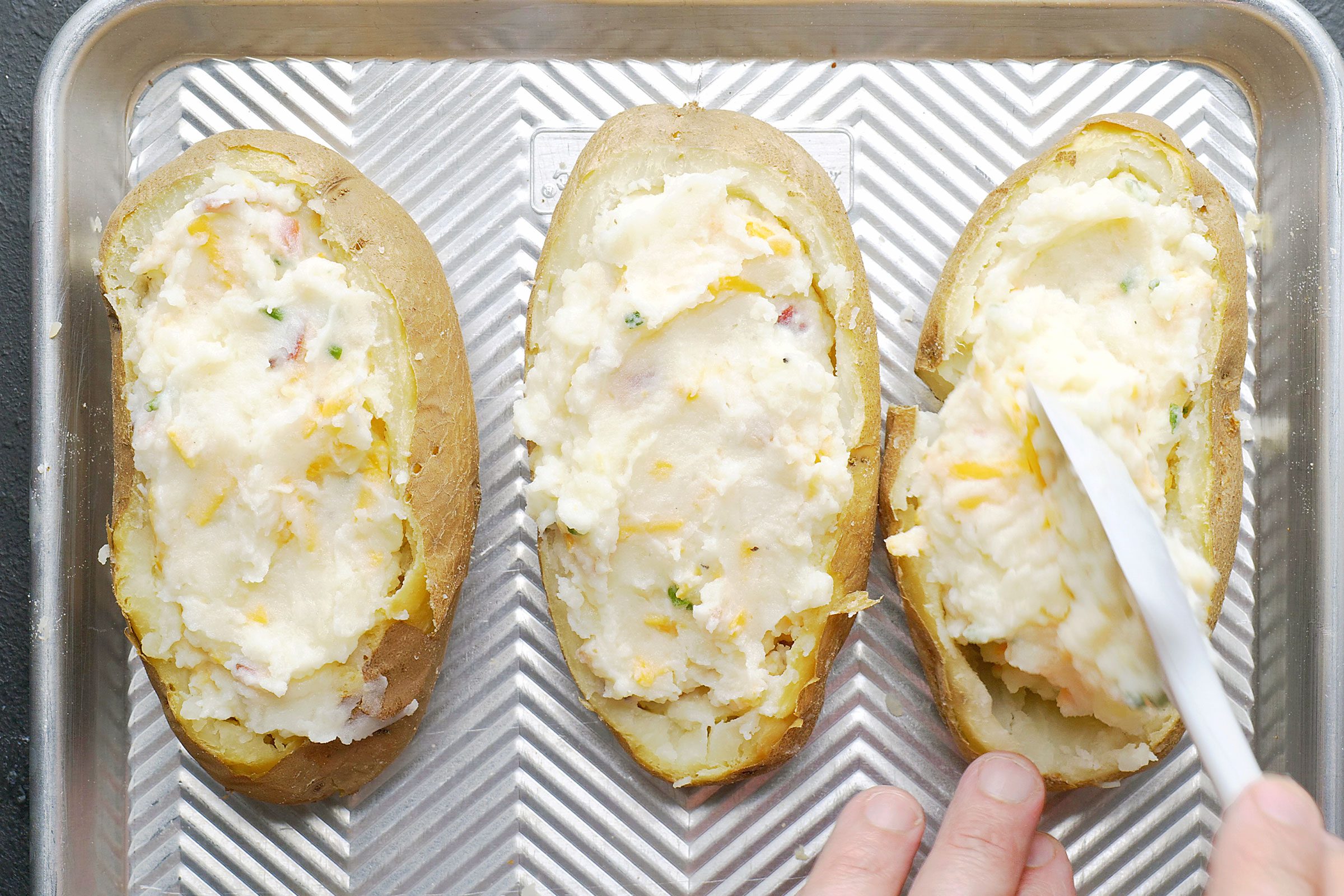 Filling the potatoes with mixed filling