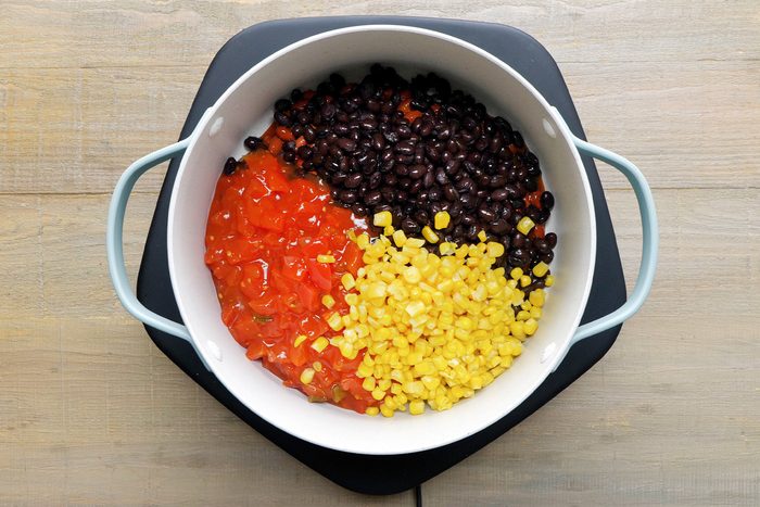Beans, tomatoes and corn mixed in a large pan to prepare Vegetarian Chili