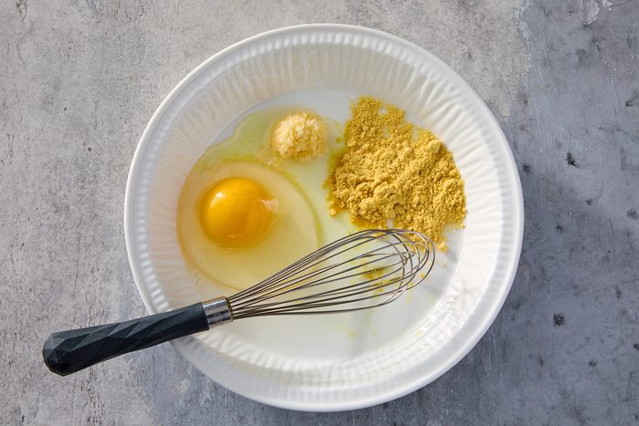 In a shallow bowl, whisk together egg substitute, mustard and garlic.