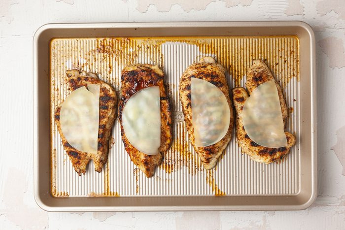 Step 3 of Taste of Home Chicken with Spinach and Mushrooms is to grill the chicken and then add the cheese and return to melt