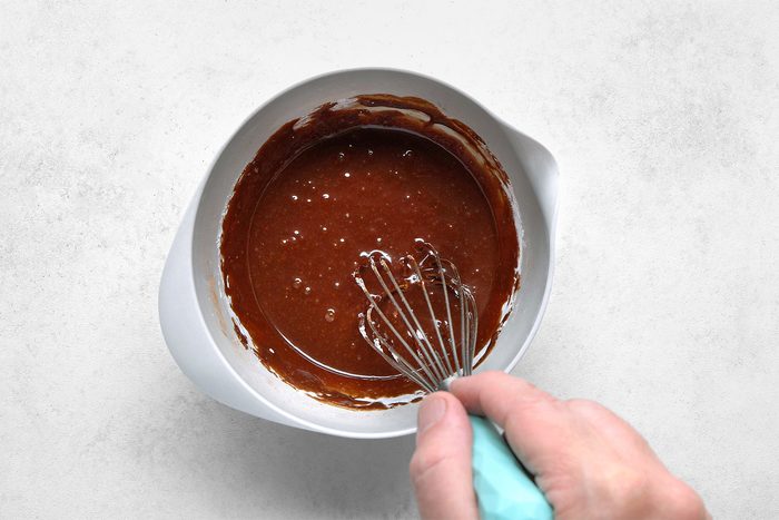 In a large bowl, whisk together water, vanilla extract and cocoa.