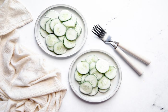 Overhead beauty shot for Taste of Home Creamy Cucumber Salad on plates being served.