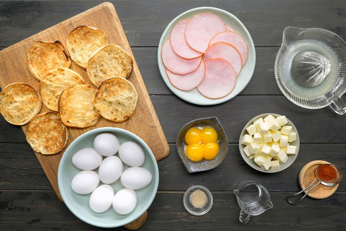 Ingredients for Eggs Benedict recipe in bowls and on board
