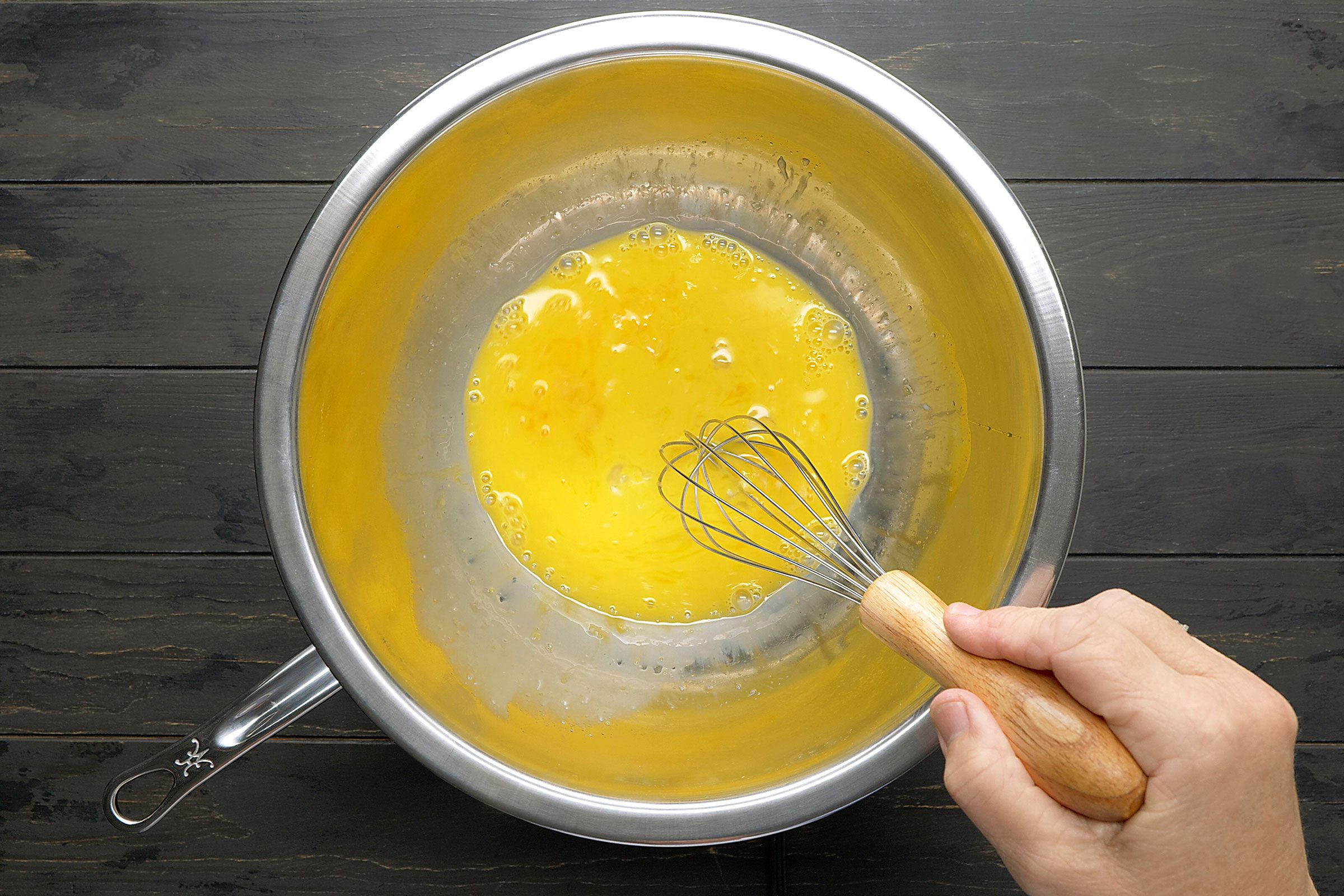 Eggs yolks whisked in a metal bowl