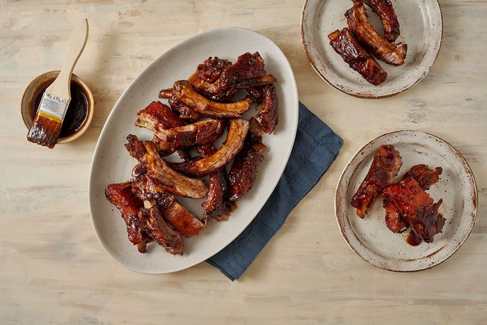 Overhead hero shot of the finished Taste of Home Honey Garlic Ribs, golden brown and caramelized, served with extra sauce on the side.