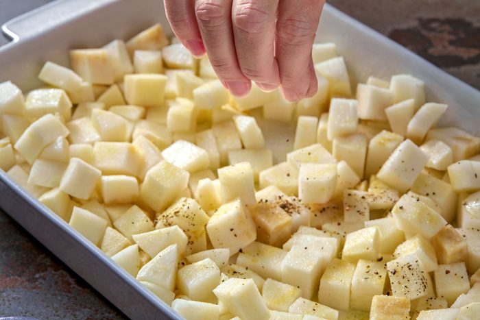 salt and pepper being sprinkled over turnips