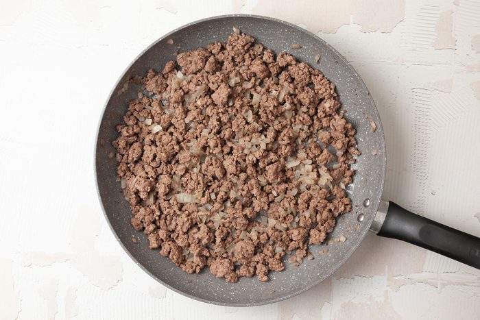 Step 1 of Taste of Home Mexi-Mac Skillet is to brown the meat and onion