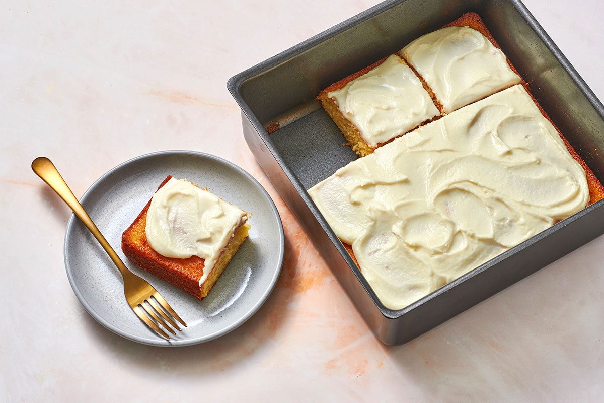 Orange cake in a pan with one portion removed