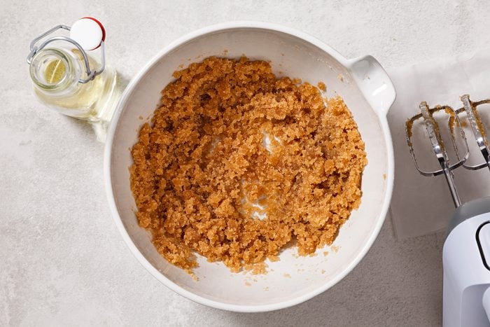 In a large bowl, beat together brown sugar and oil until combined.