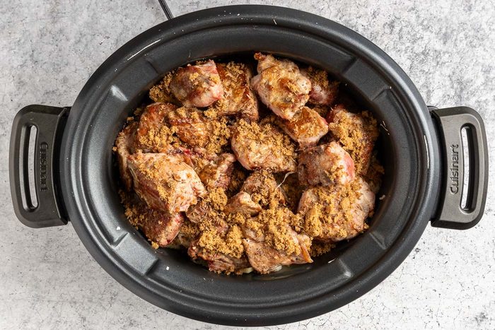 Taste of Home Slow Cooker Pork and Sauerkraut photo of the spareribs and seasonings added to the slow cooker.