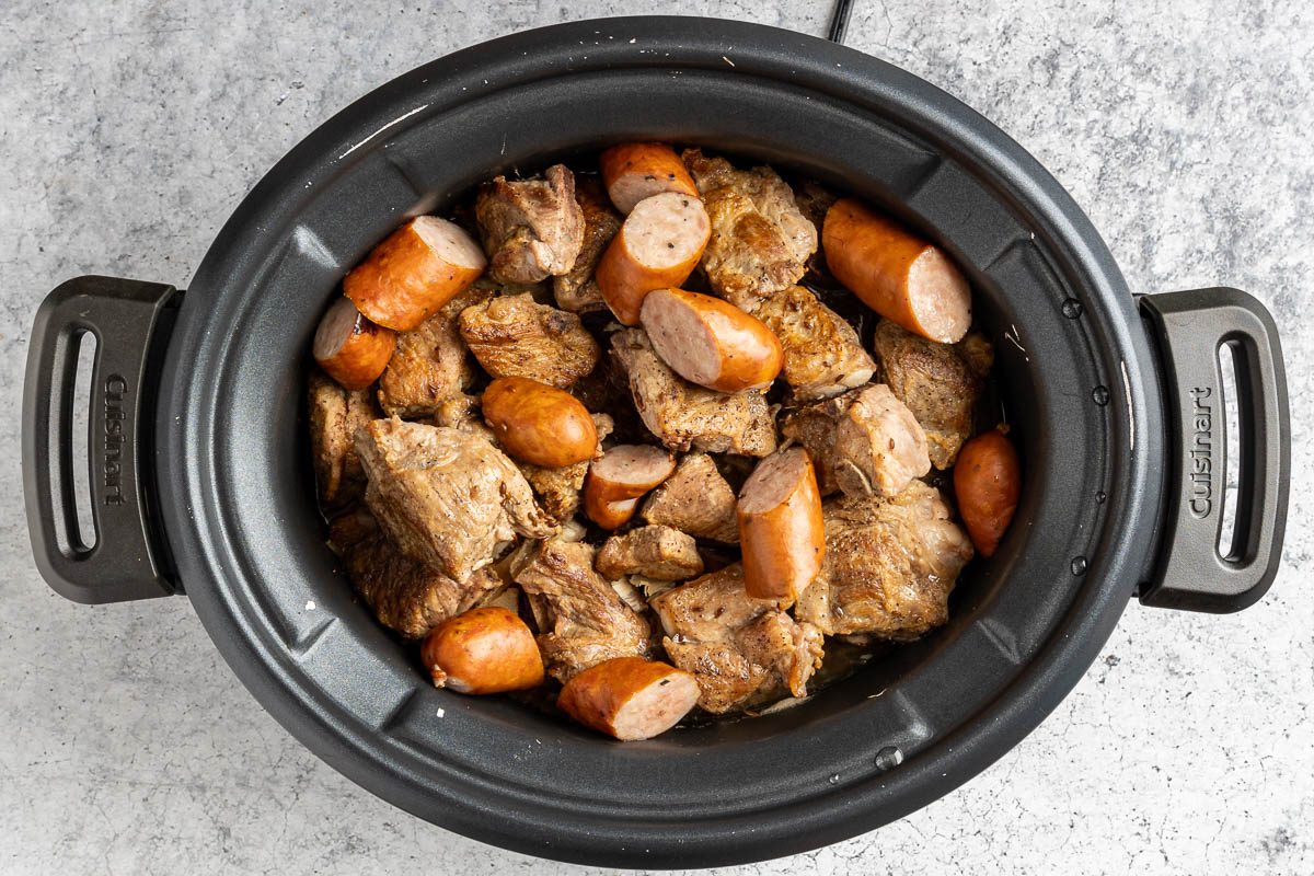 Taste of Home Slow Cooker Pork and Sauerkraut photo of the sausage added and all ingredients cooked in the slow cooker.