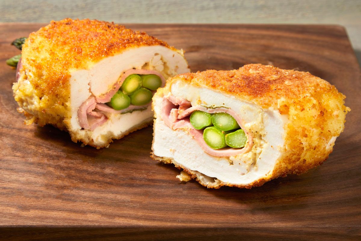 Close up shot of Asparagus-Stuffed Chicken Rolls on a wooden surface