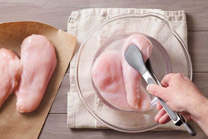 adding chicken breasts to salt and water mixture to let it brine