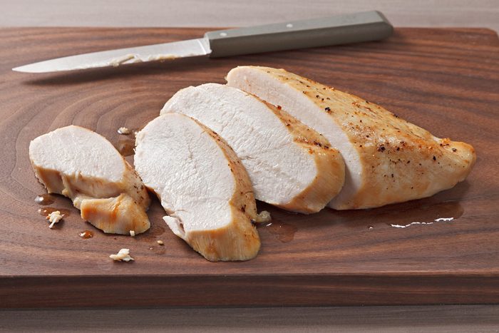 Chicken Breasts baked and cut into pieces on a wooden board