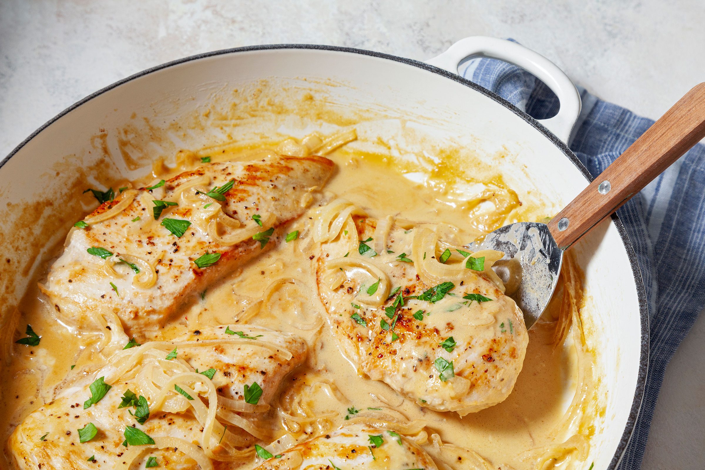 Chicken Dijon sprinkled with some parsley on top in a large skillet