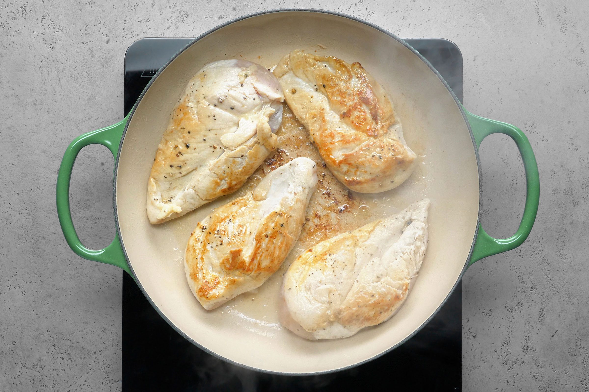 Browning the chicken breasts by tossing them on some hot oil in a large skillet