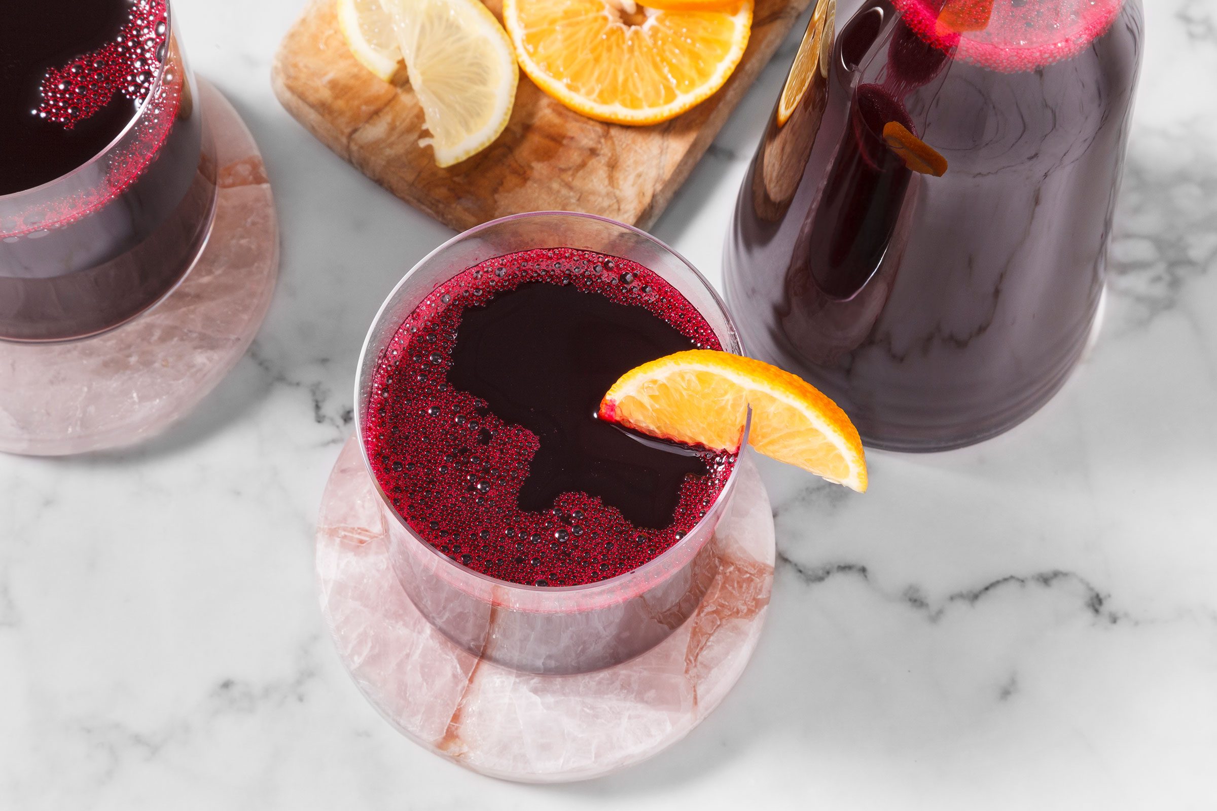 Beet juice served in a glass and placed on top of a coaster with lemon slice on the rim of the glass
