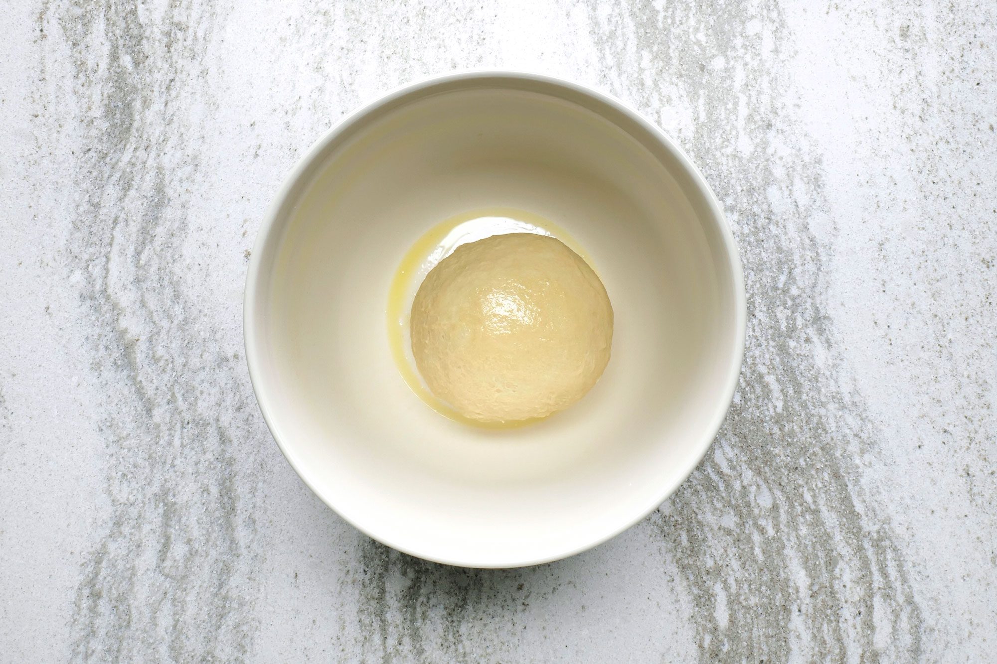Place the dough ball in a greased bowl, turning once to grease the top