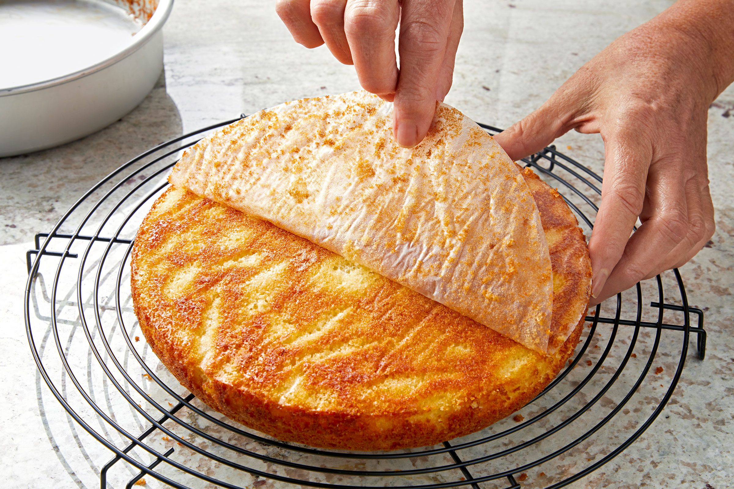Removing parchment from Lemon Olive Oil Cake on wire rack 
