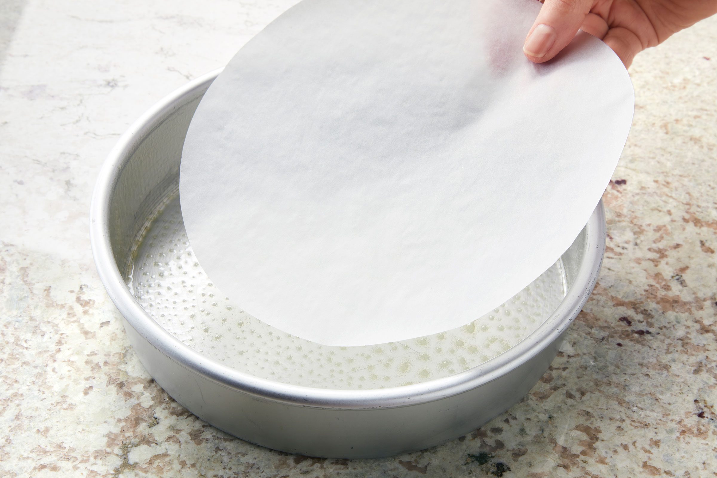 Lining greased round baking pan with parchment