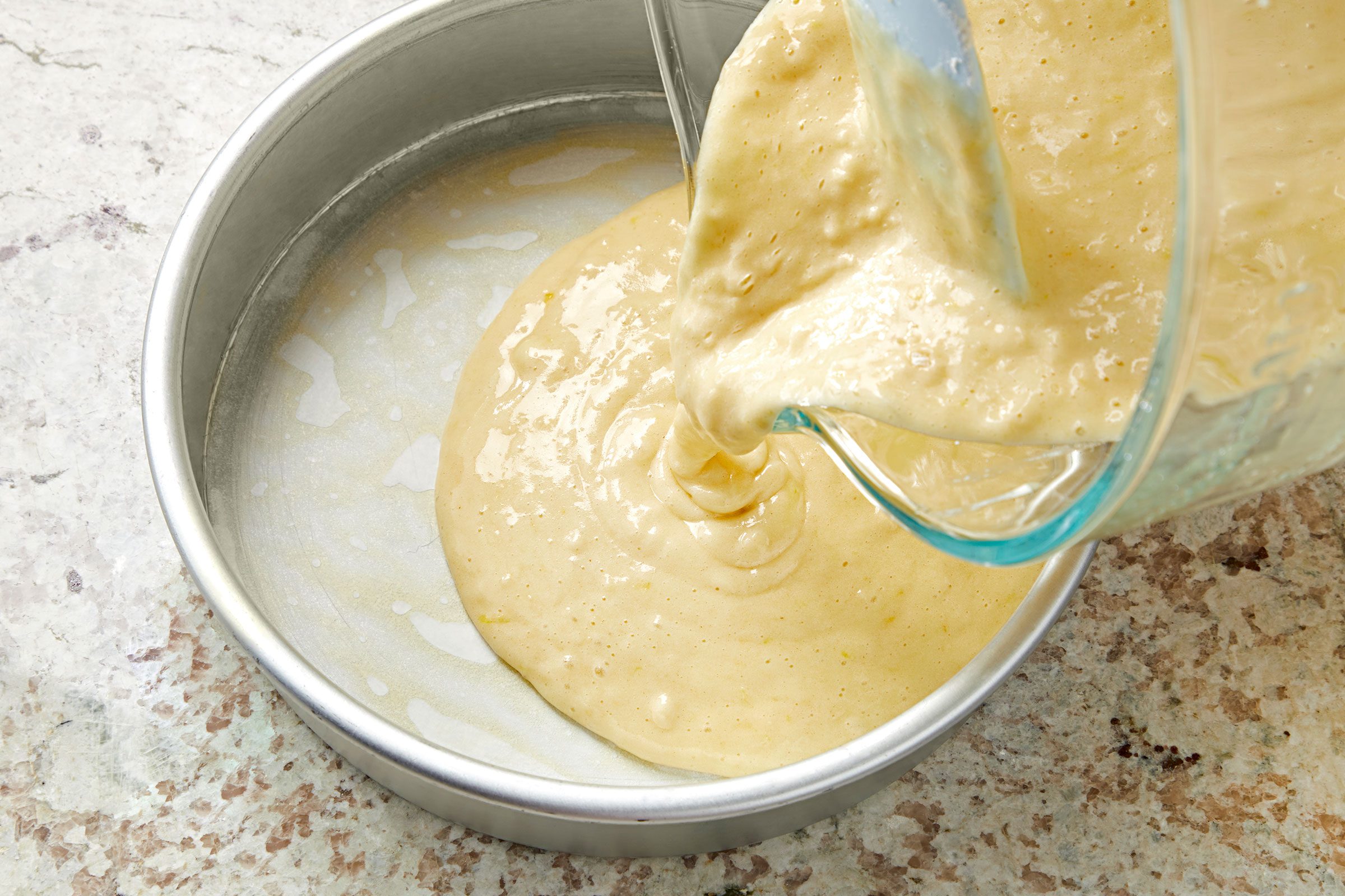 Transferring cake batter into greased cake pan