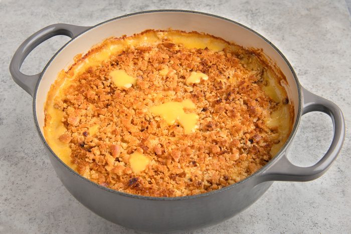 3/4th shot of a Chicken broccoli casserole dish filled with a creamy, cheesy dish topped with a crunchy breadcrumb topping; it is sitting on a light gray countertop