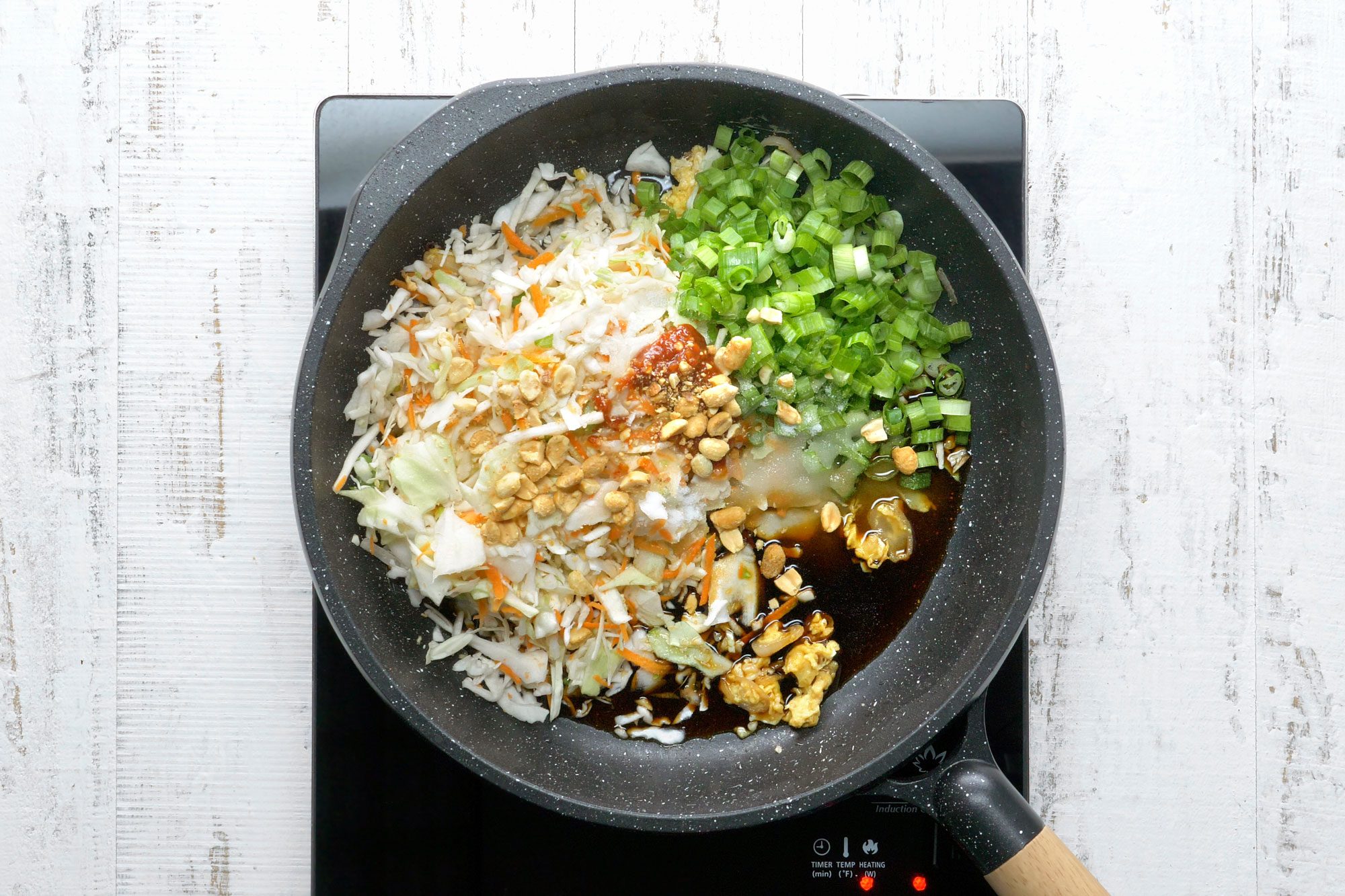 Add the coleslaw mix, green onion, vinegar, sugar, soy sauce, fish sauce, chili garlic sauce, lime juice and peanuts, heat through