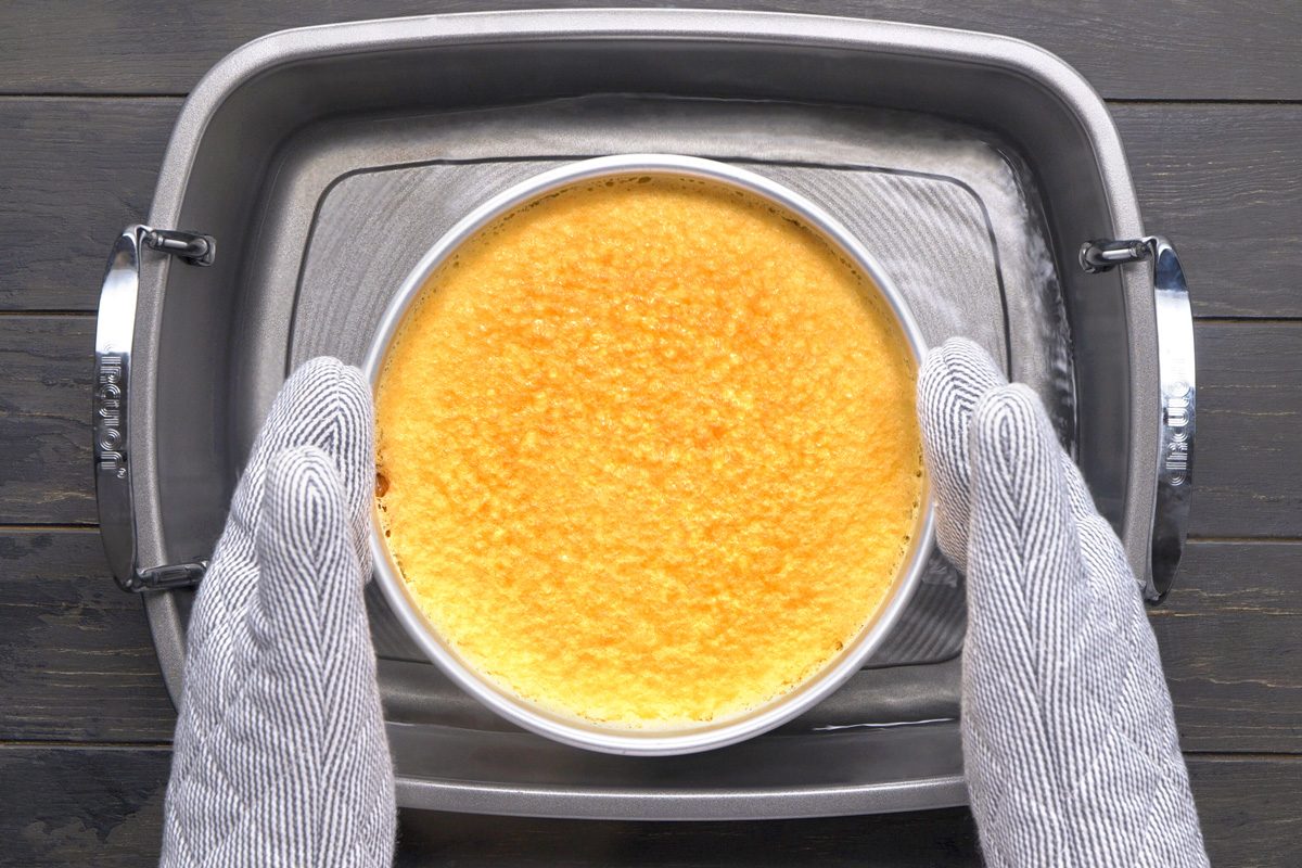 cake pan being removed from water bath
