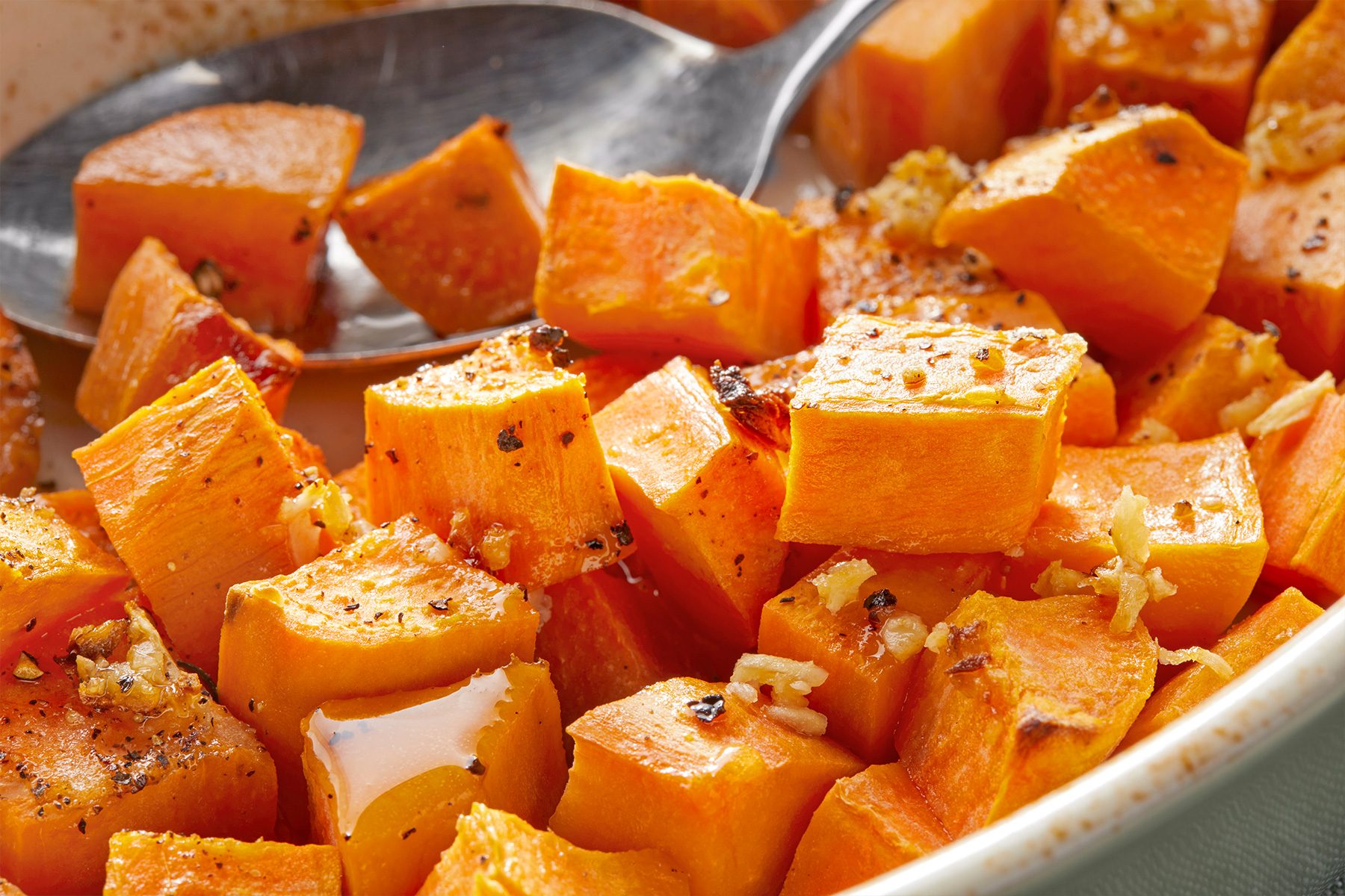 Close up of Roasted Sweet Potatoes in a white bowl 