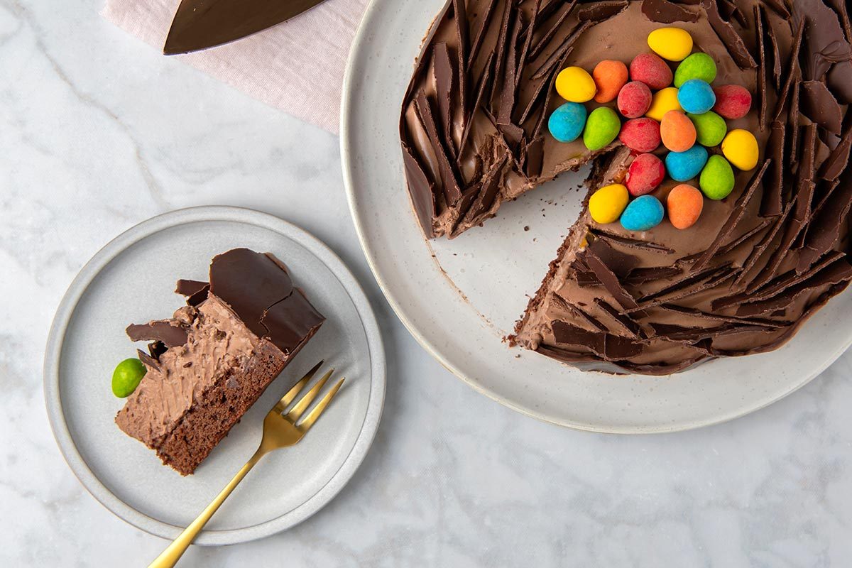 Easter Nest Torte with a slice on a plate, topped with candy eggs