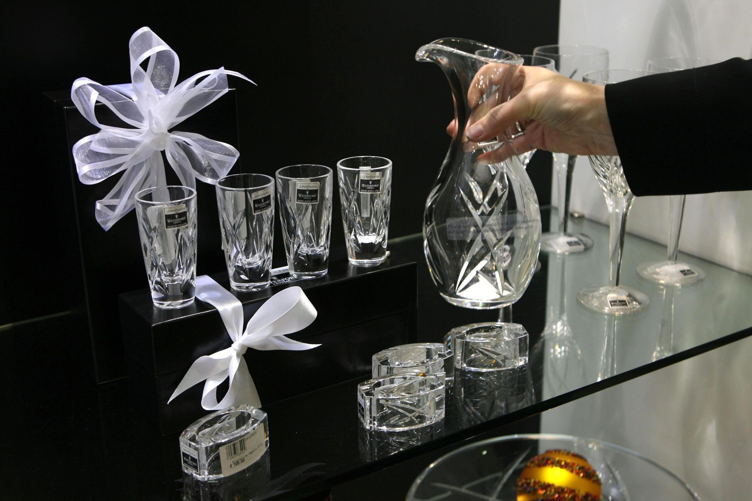 Waterford Crystal glasses, flutes, and pitchers on a display table with purple bows