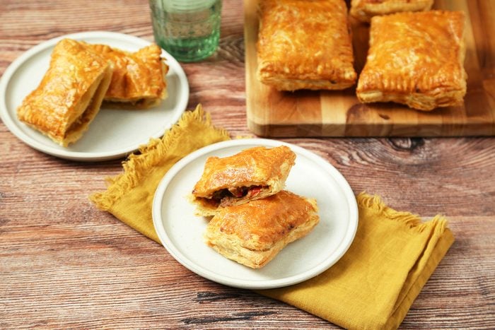 Louisiana Meat Pies served in white plates on a yellow fabric on wooden counter