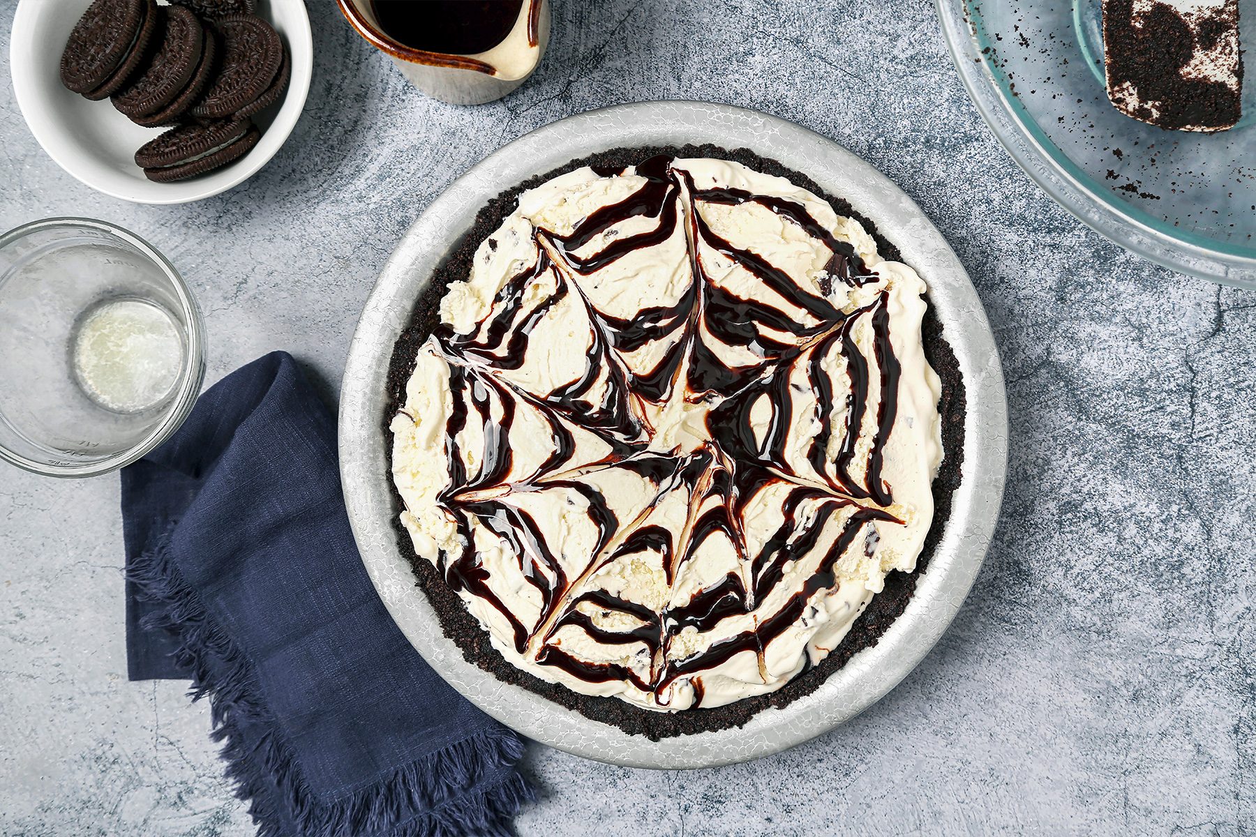 prepping mud pie in a bowl with Oreo and chocolate syrup