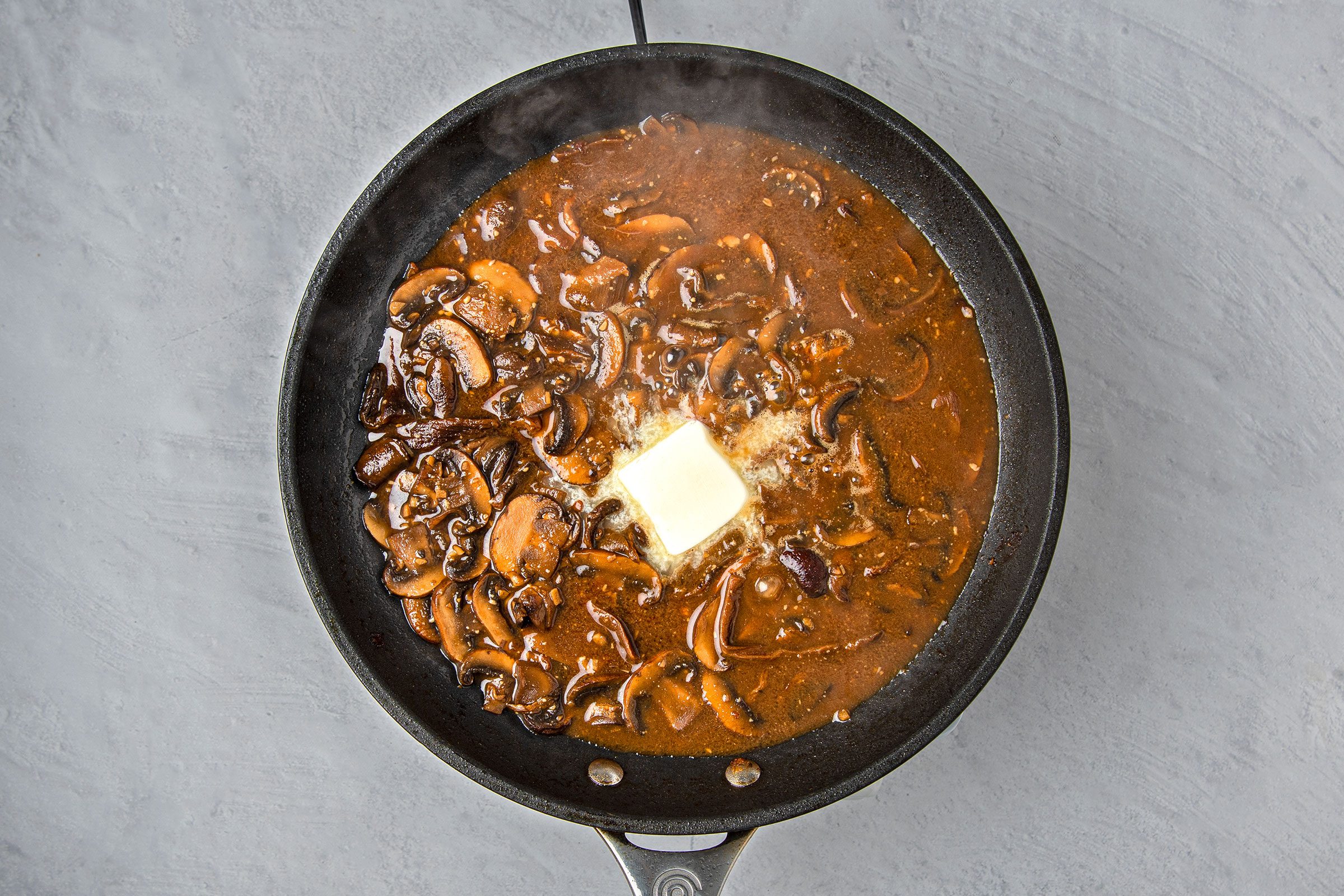 Chicken broth, brown sugar, Dijon and Worcestershire sauce in the mushroom mixture with butter on top
