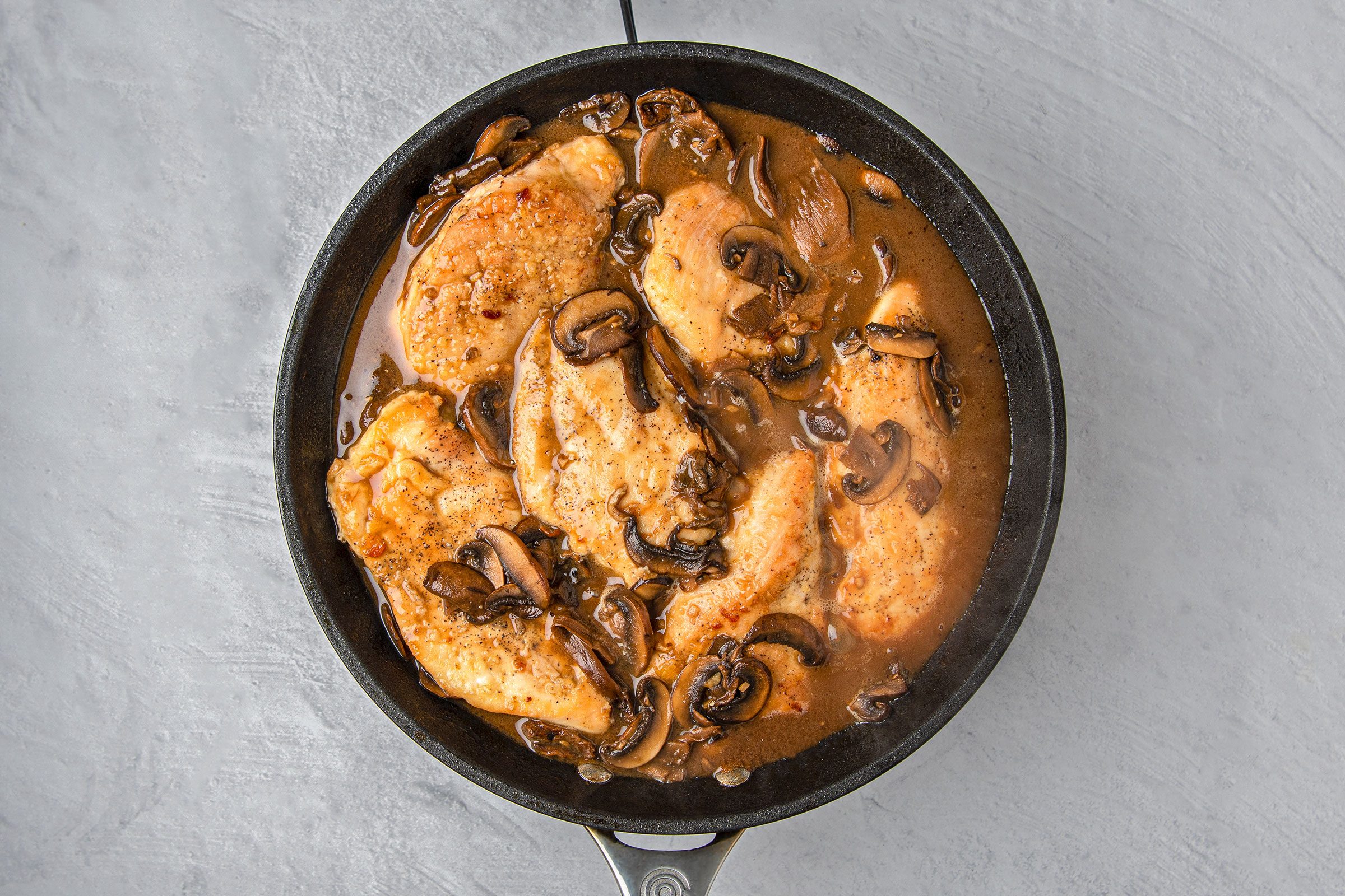 Added cooked chicken to the mushroom sauce in a skillet