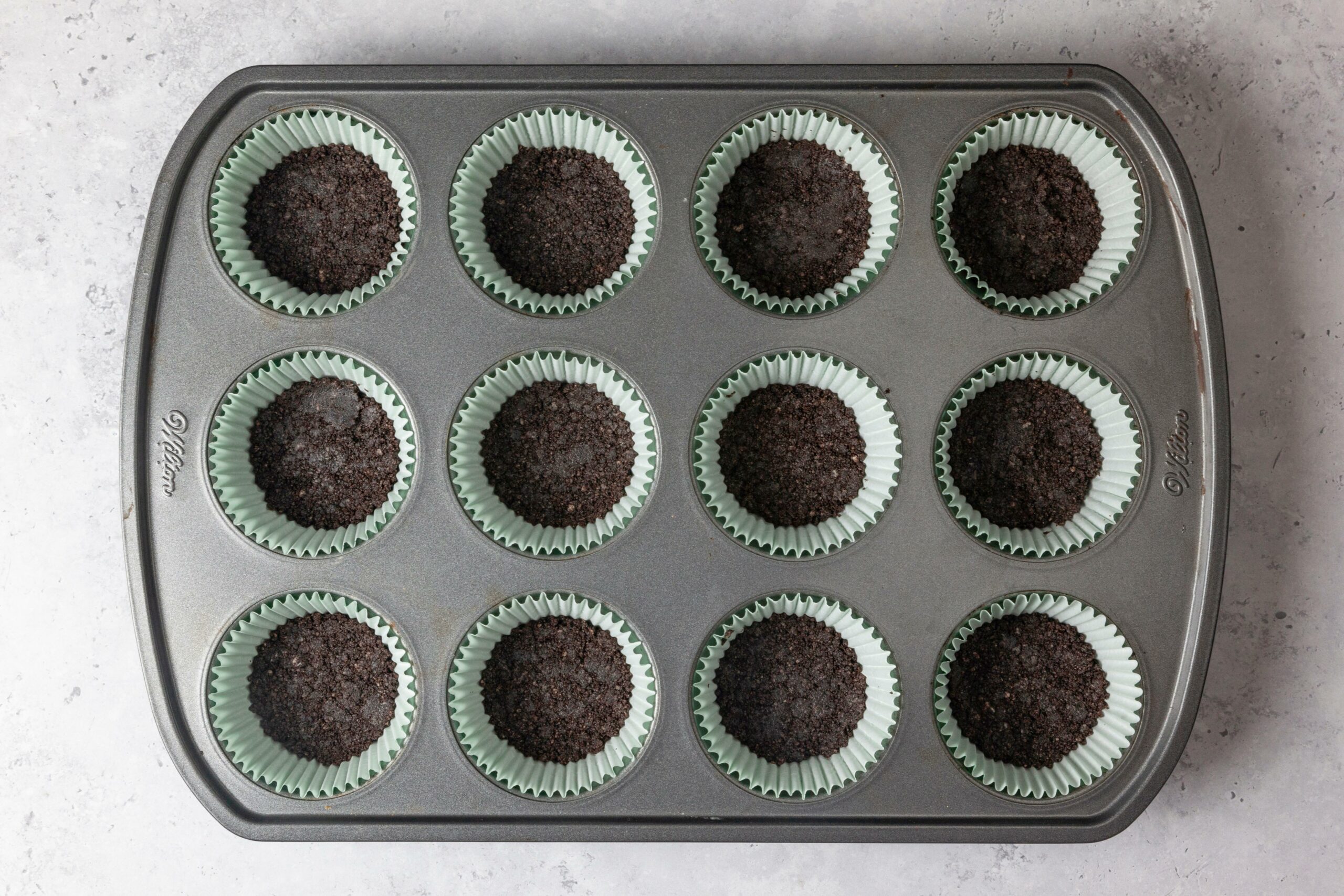 Oreo crusts set in a tray, ready to bake