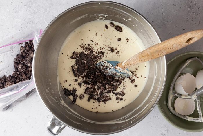 Sugar, Eggs and oreo being mixed in a large bowl