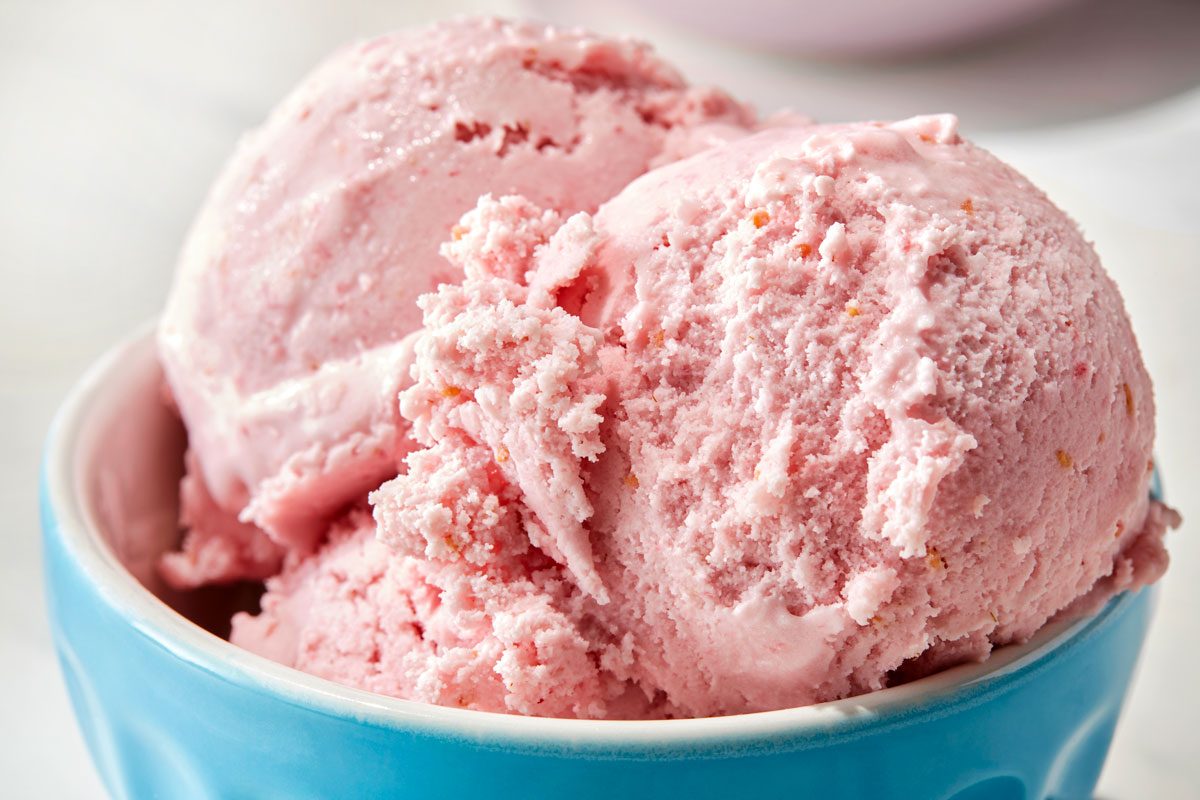 Raspberry ice cream served in a blue cup.