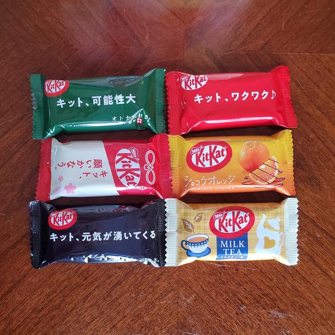 Six Japanese mini Kit Kats of different flavors on a wooden table