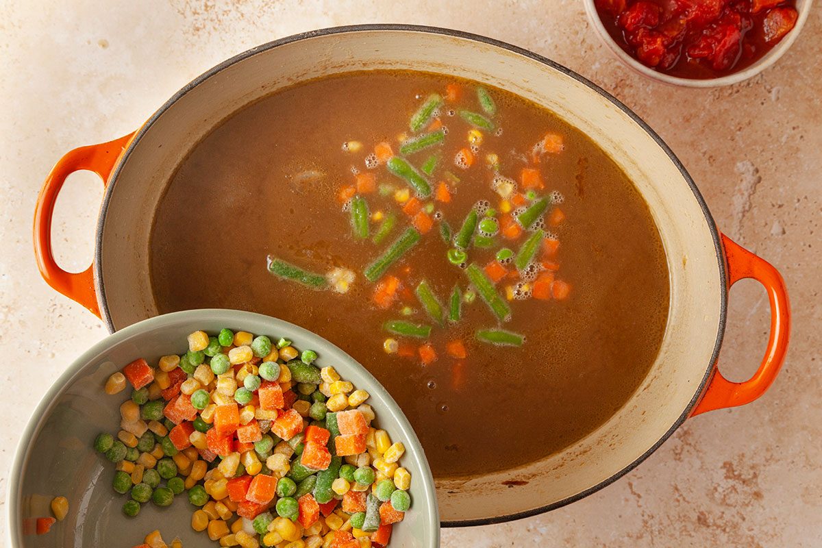 frozen vagetable being poured in the soup