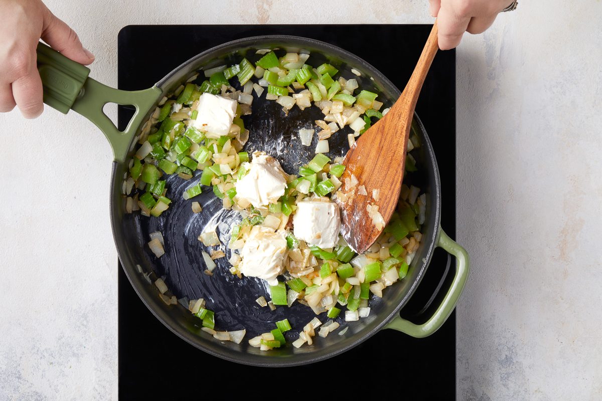 sautéing onions and celery in a large skillet with cream cheese stirred in