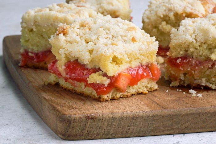 Close-up shot of Strawberry Rhubarb Coffee Cake; served on a wooden tray; marble surface;